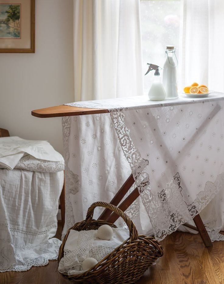 the table is covered with white linens and has an ironing board next to it