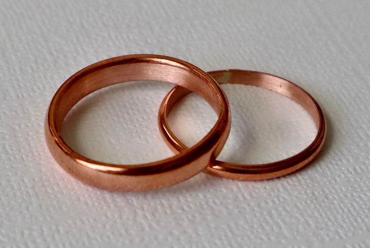 This copper wedding ring set is a casual but beautiful set of rings for the person looking for an affordable option for that special day.    Each band is made of pure 99.9%  copper, handmade at time of purchase.   Personalize your bands with a date or words on the inside of band.  choose your personalization at checkout.  SIZE The men's ring band is 14 gauge copper wire women's band is 16 gauge copper wire PROCESSING TIME This ring will take 1-3 business days to create and ready to ship.  SHIPPI Rose Gold Copper Ring For Anniversary, Handmade Rose Gold Stackable Rings For Wedding, Adjustable Copper Wedding Rings, Adjustable Copper Rings For Wedding, Elegant Rose Gold Copper Rings, Gold Copper Ring For Wedding, Gold Copper Wedding Ring, Copper Wedding Rings, Copper Wedding Band