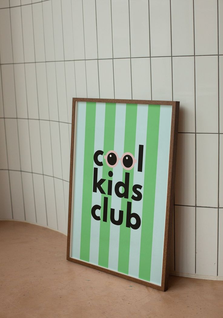 a sign that says cool kids club in black and green on a white tiled wall