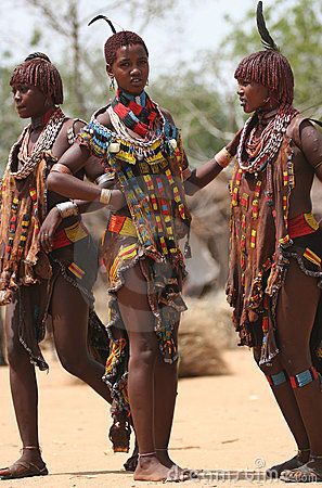 three african women in traditional dress dancing