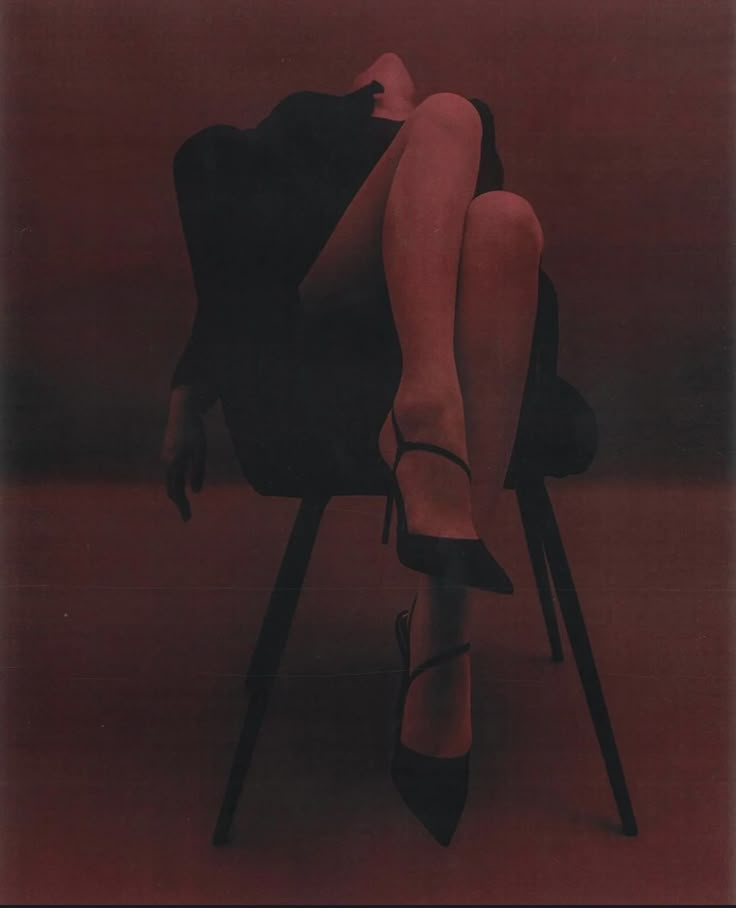 a woman is sitting in a chair with her legs up on the back of a chair