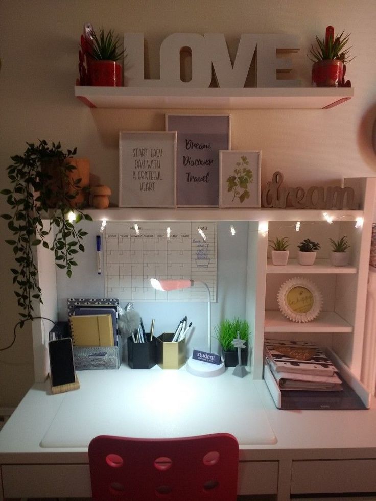 a desk with some books and plants on it, next to a shelf that says love