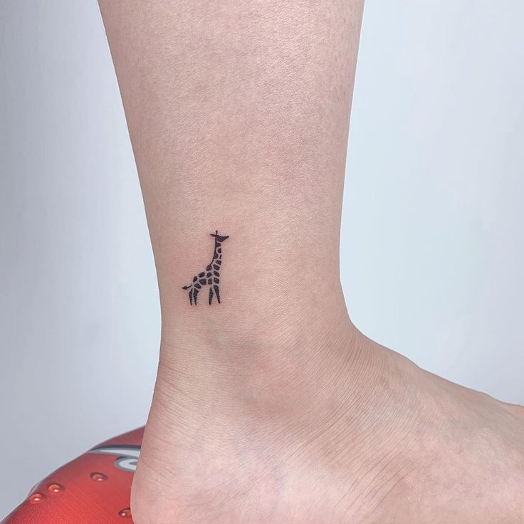 a small giraffe tattoo on the ankle