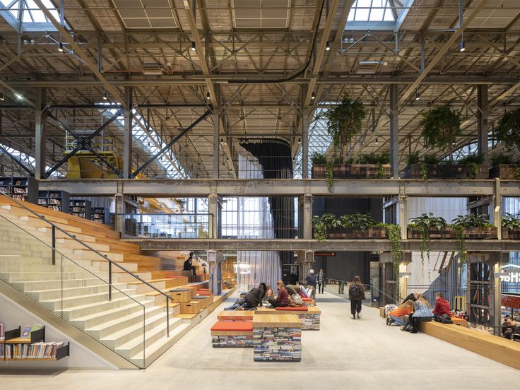 people are sitting on benches in the middle of an open building