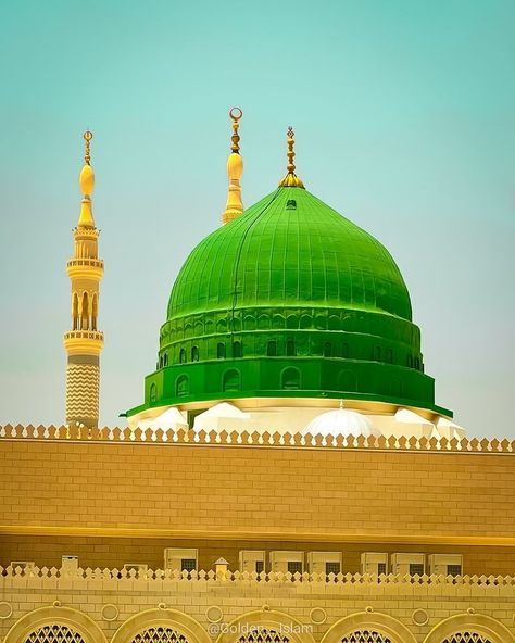 a green dome on top of a building with two minalis in the background,