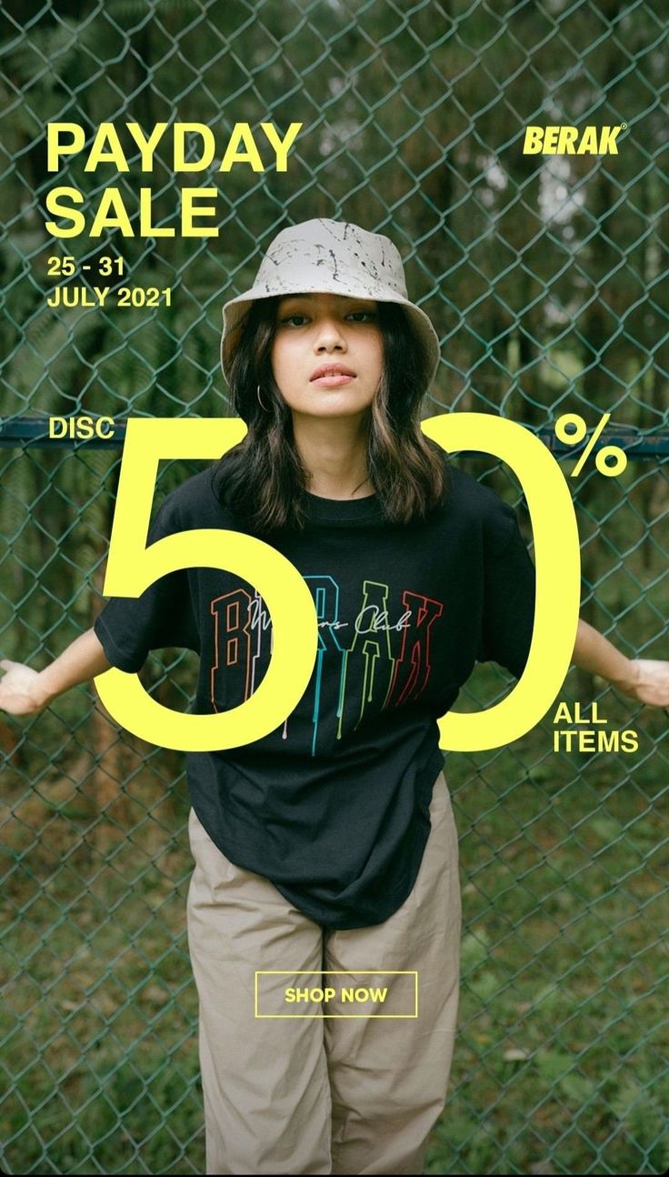 a woman standing in front of a fence with her hands on her hips and wearing a hat