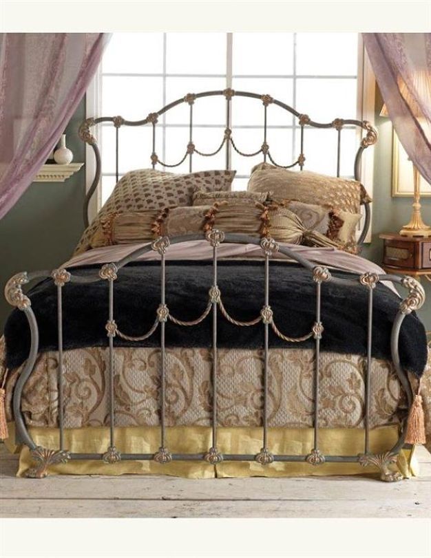 a metal bed with black and gold sheets