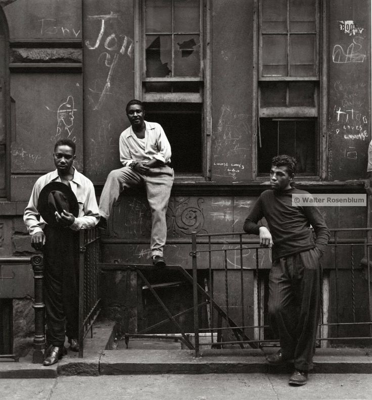 three men standing on the side of a building