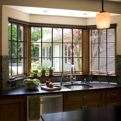 a kitchen with an island sink and large windows