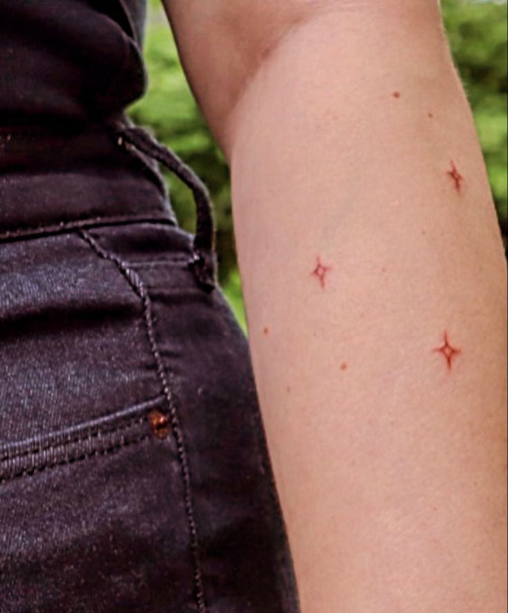 3 stars tattooed on arm Brown Ink Star Tattoo, Red Ink Star Tattoo, Red Stars Tattoo, Sparkle Freckle Tattoo, Brown Star Tattoo, Freckle Star Tattoo, Red Sparkle Tattoo, Red Tiny Tattoo, Star Freckle Tattoo