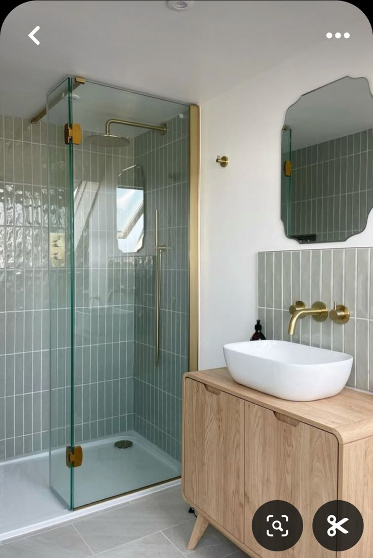 a bathroom with a sink, mirror and walk in shower next to a wooden cabinet