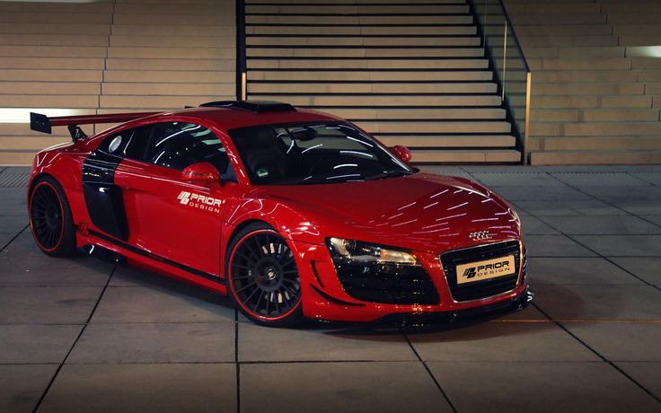 a red sports car parked in front of some stairs