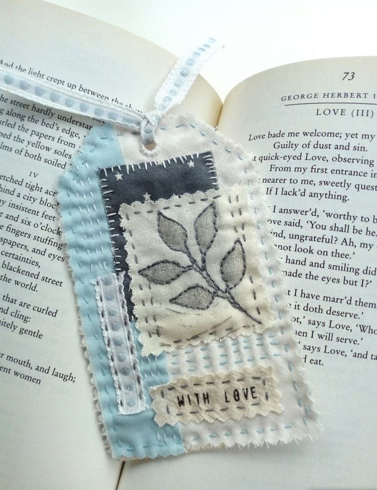 an open book with a piece of fabric hanging from it's cover and the words love on it