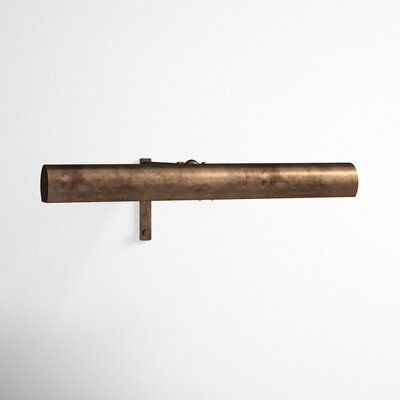 an old brass pipe is hanging on the wall in front of a white wall with no one around it