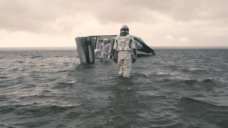 an astronaut walking out of the ocean