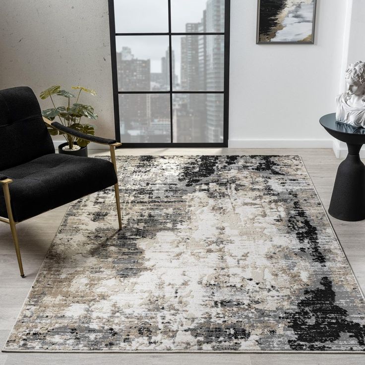 a black and white area rug in a living room with a chair, table and window