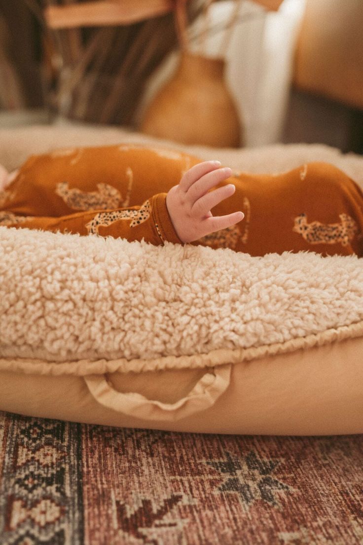 a baby laying on top of a dog bed