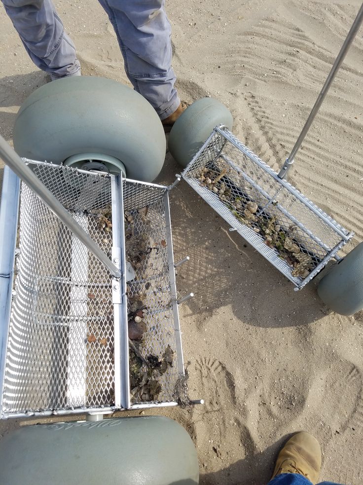 a man standing next to a metal container filled with dirt