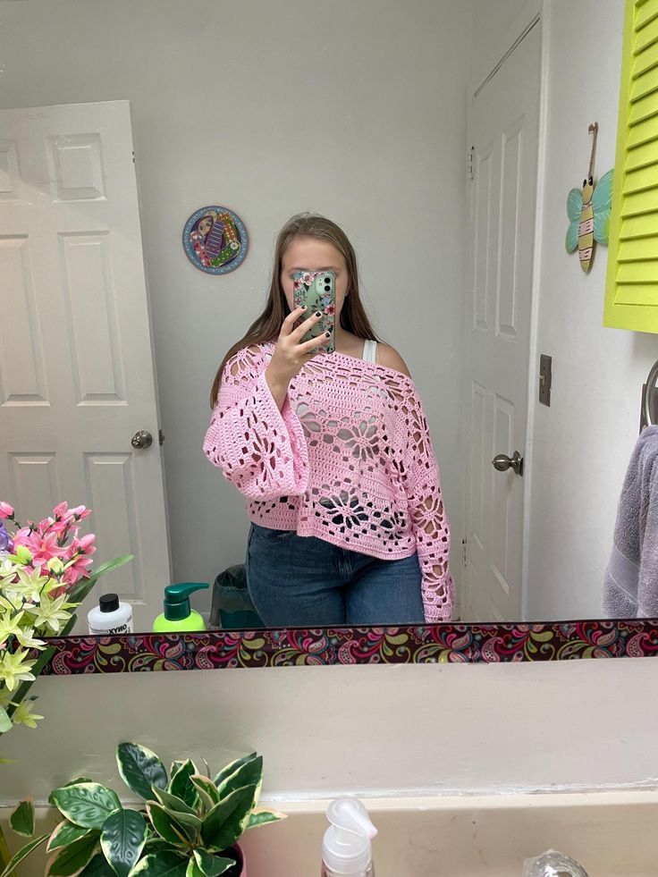 a woman taking a selfie in front of a bathroom mirror with her cell phone