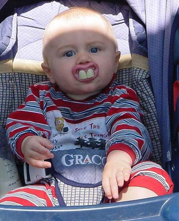 a baby sitting in a stroller with his mouth open and tongue out to the side