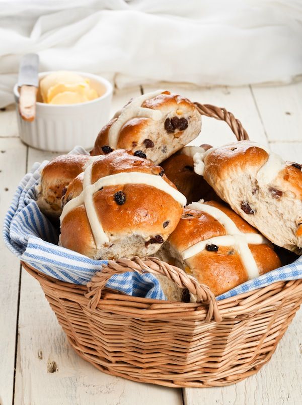 a basket filled with hot cross buns sitting on top of a table