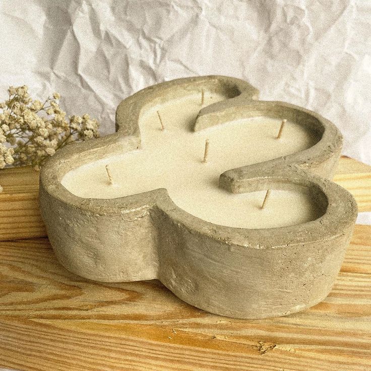 a concrete candle holder sitting on top of a wooden table