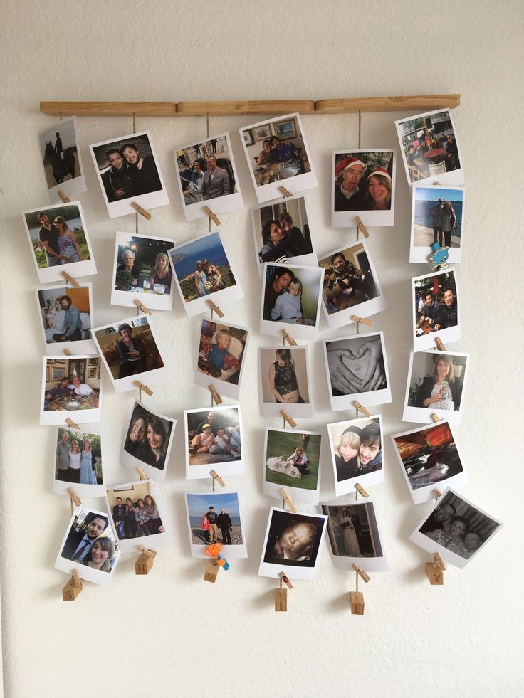 several pictures hanging on a wall with clothes pins attached to them and photos pinned to the wall