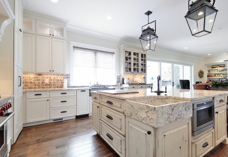 a large kitchen with an island in the middle and lots of cabinets on both sides