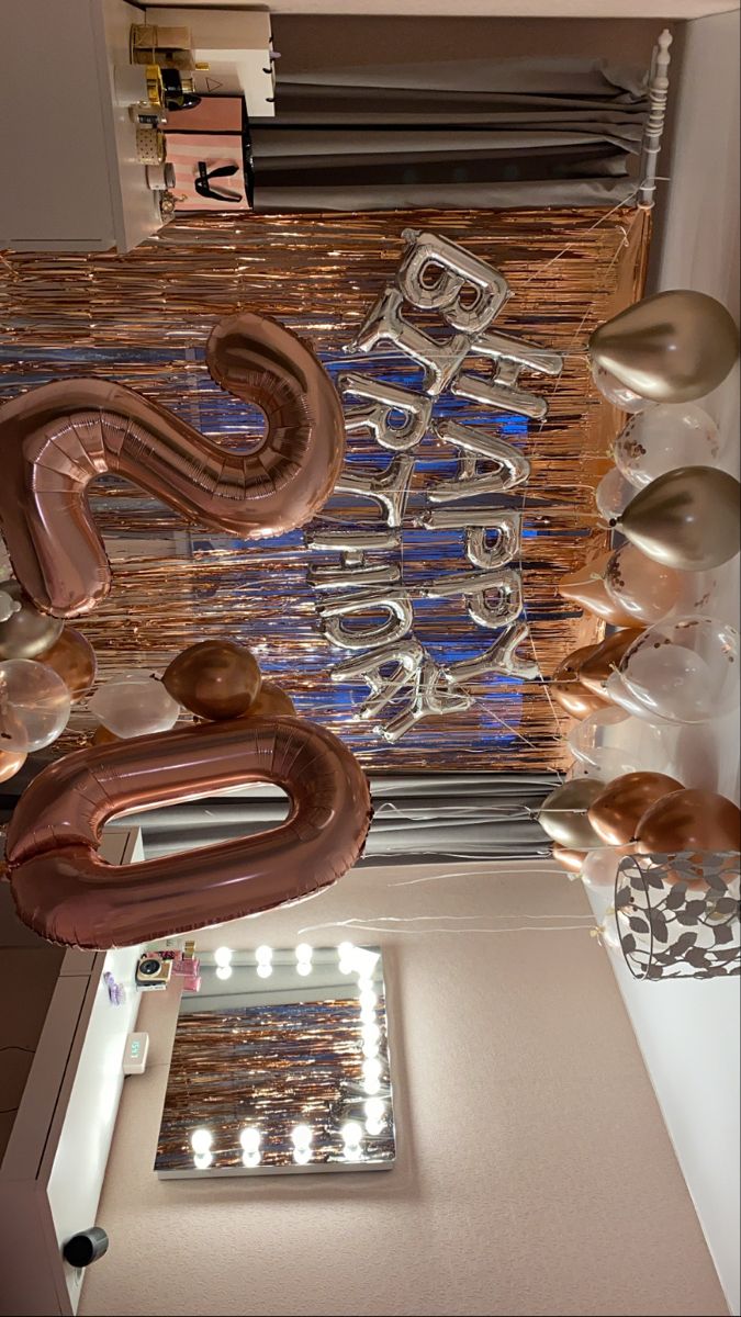 the balloons are hanging from the ceiling above the mirror and other items in the room