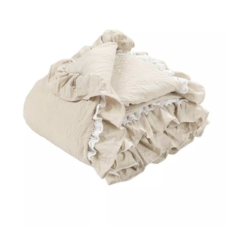 a white blanket with ruffles on it and a pillow in the middle is laying down