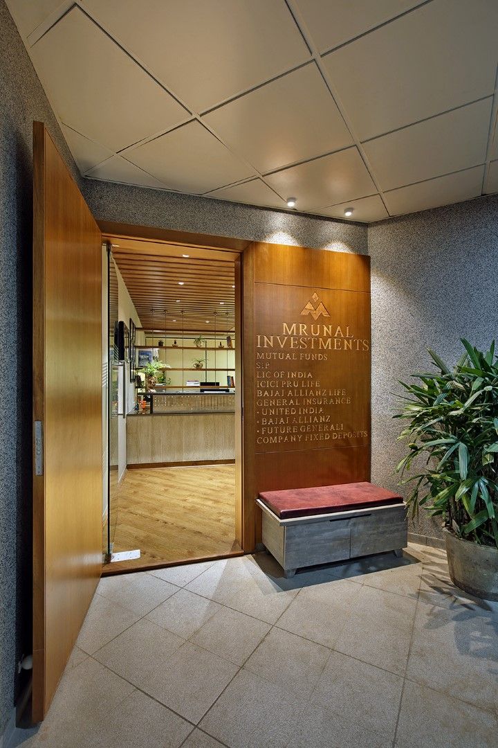 the entrance to an office building with a bench and potted plant on the floor