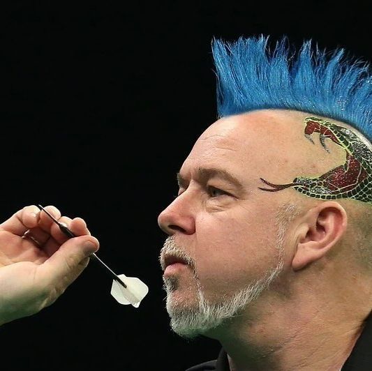 a man with blue hair and tattoos on his face is holding a toothbrush to his mouth