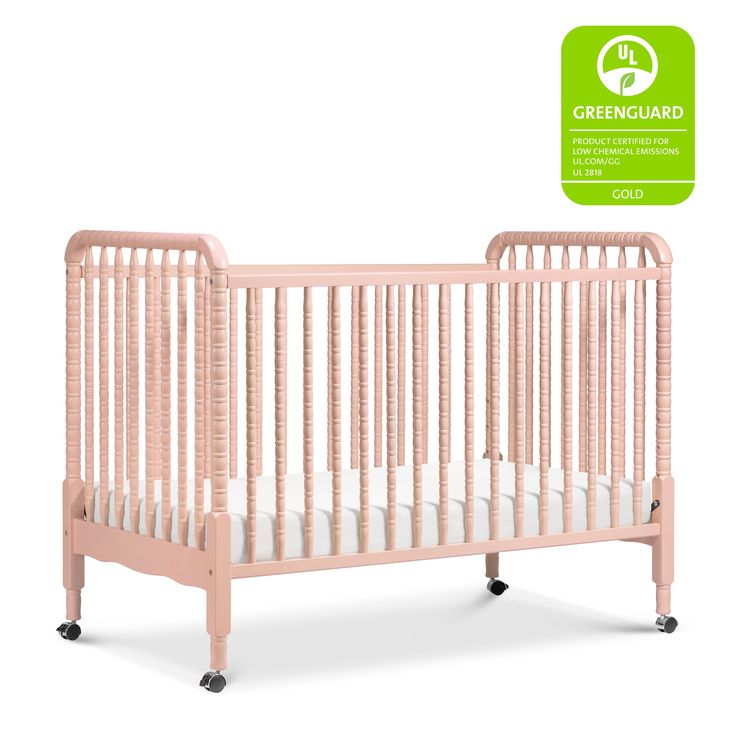 a pink crib with the greenguard logo above it