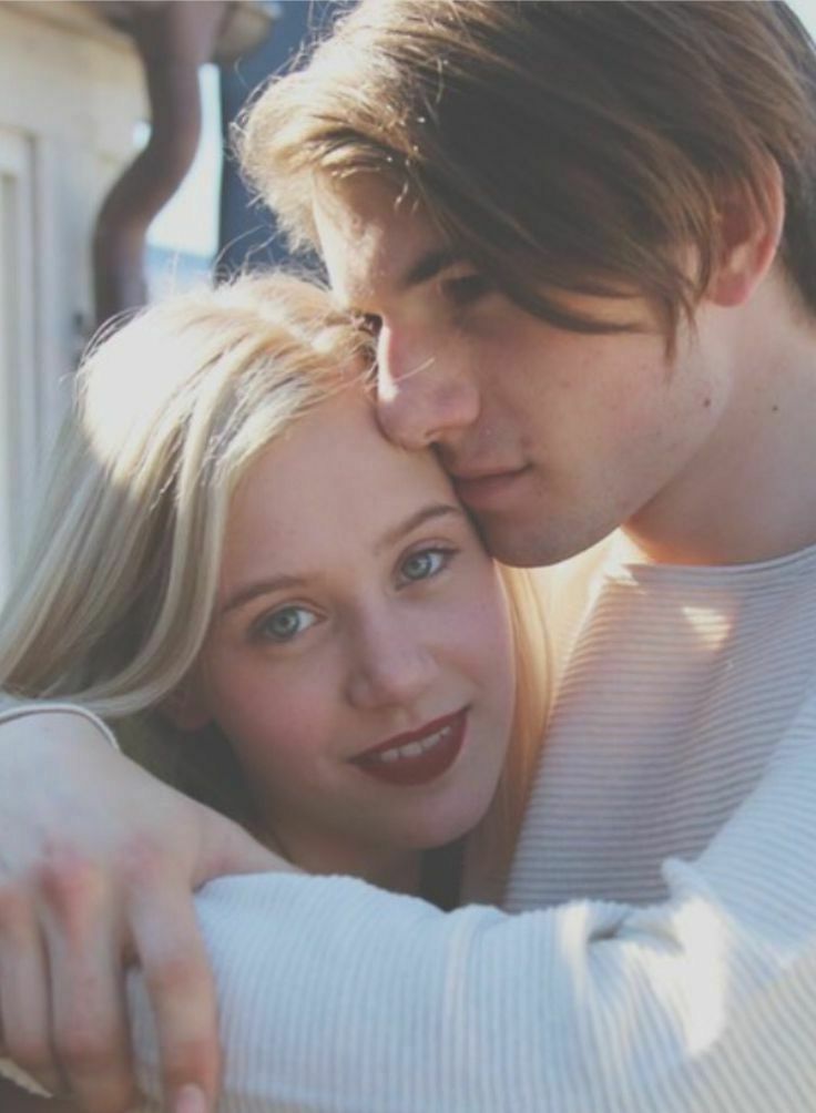 a man and woman embracing each other in black and white