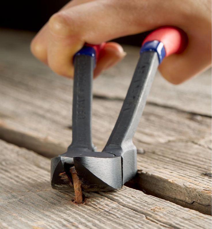 a pair of hammers being used to sharpe down nails on a piece of wood