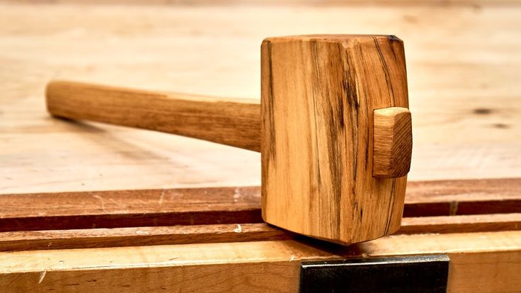 a wooden mallet on top of a piece of wood