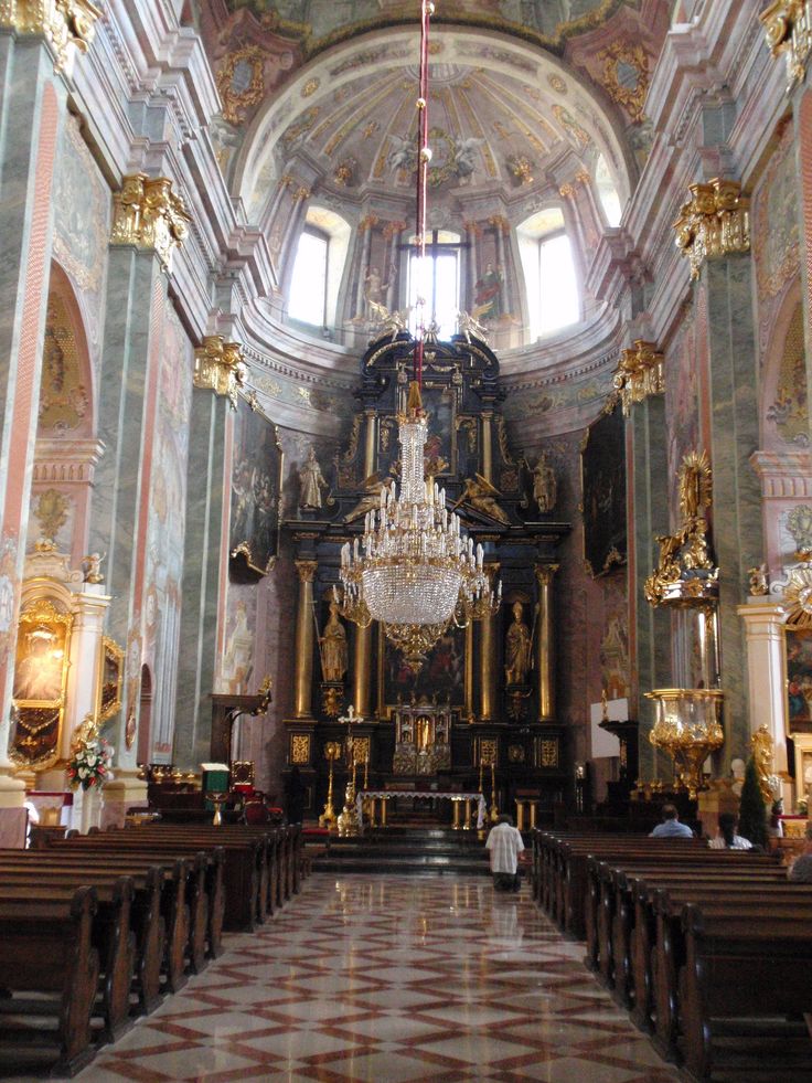 the inside of a church with chandelier and pews