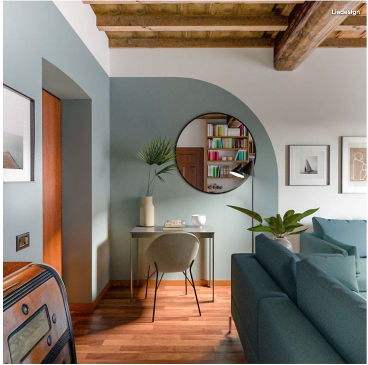 a living room filled with furniture and a round mirror on the wall above a table