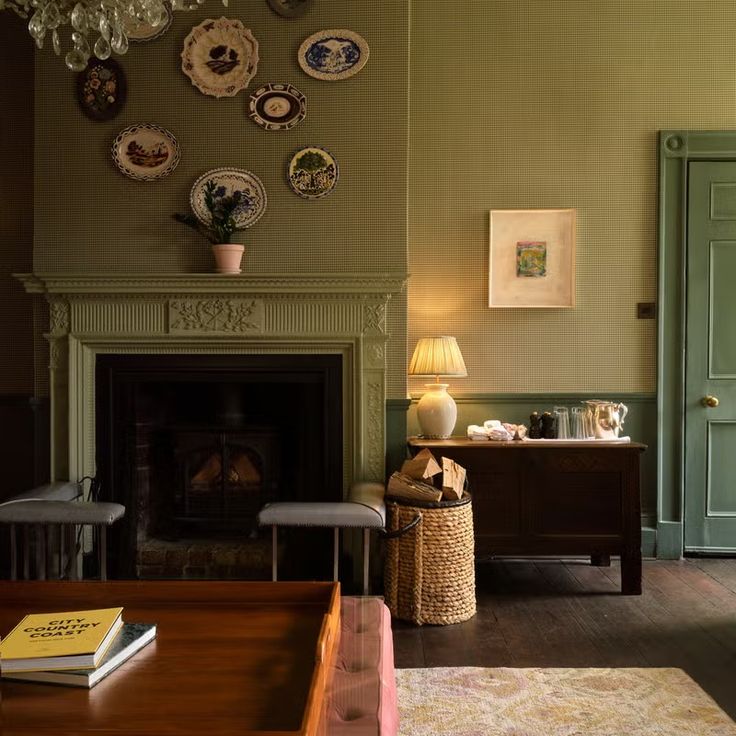 a living room filled with furniture and a fire place next to a fireplace covered in plates on the wall