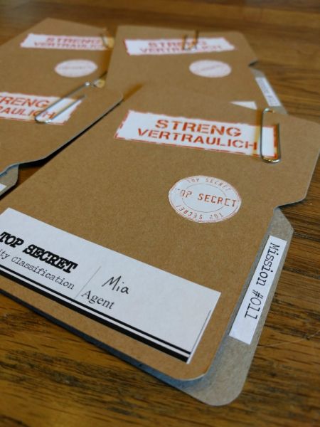 two brown boxes with stickers on them sitting on a wooden table