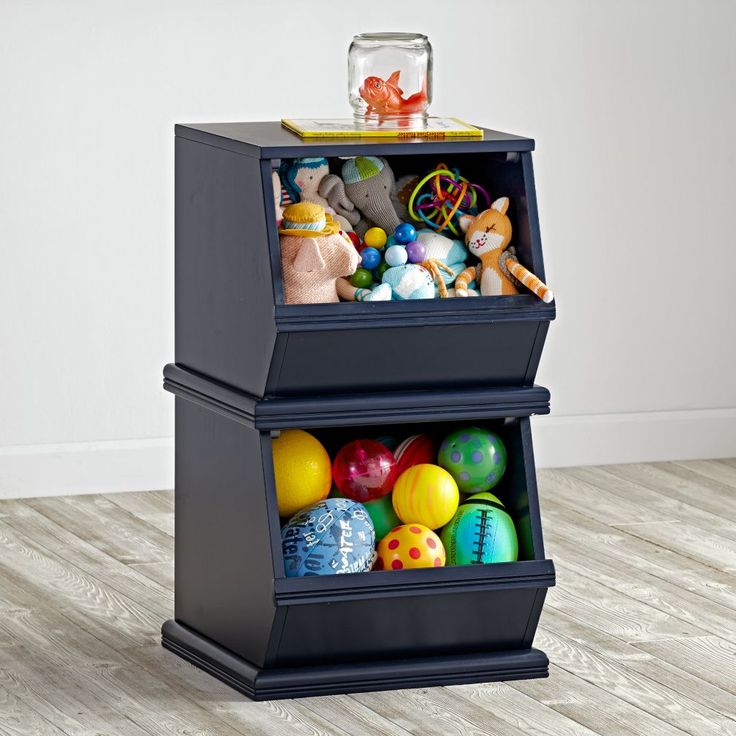 two bins filled with toys on top of a hard wood floor next to a white wall