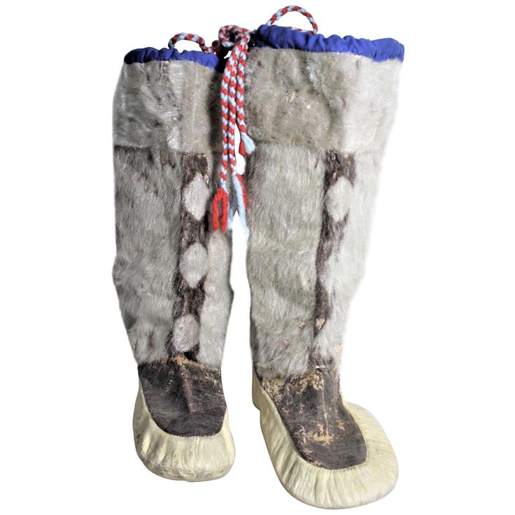 This pair of vintage Inuit mukluks are presumed to have been made in Canada in circa 1950 in the Indigenous American Folk Art style. The upper portions are made with fur and the bottom or 'boot' is composed of leather. There are wool ties done in red and a steel blue held by a deep blue felt upper border. Please note that there is age damage to the fur and leather as presented in the photos. Native American Boots, Mukluk Boots, Americana Vintage, Native American Clothing, Indigenous Americans, Wool Tie, Crazy Outfits, American Folk Art, Arte Popular