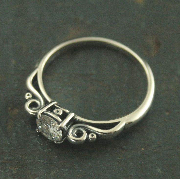 a close up view of a silver ring with a diamond on it's side