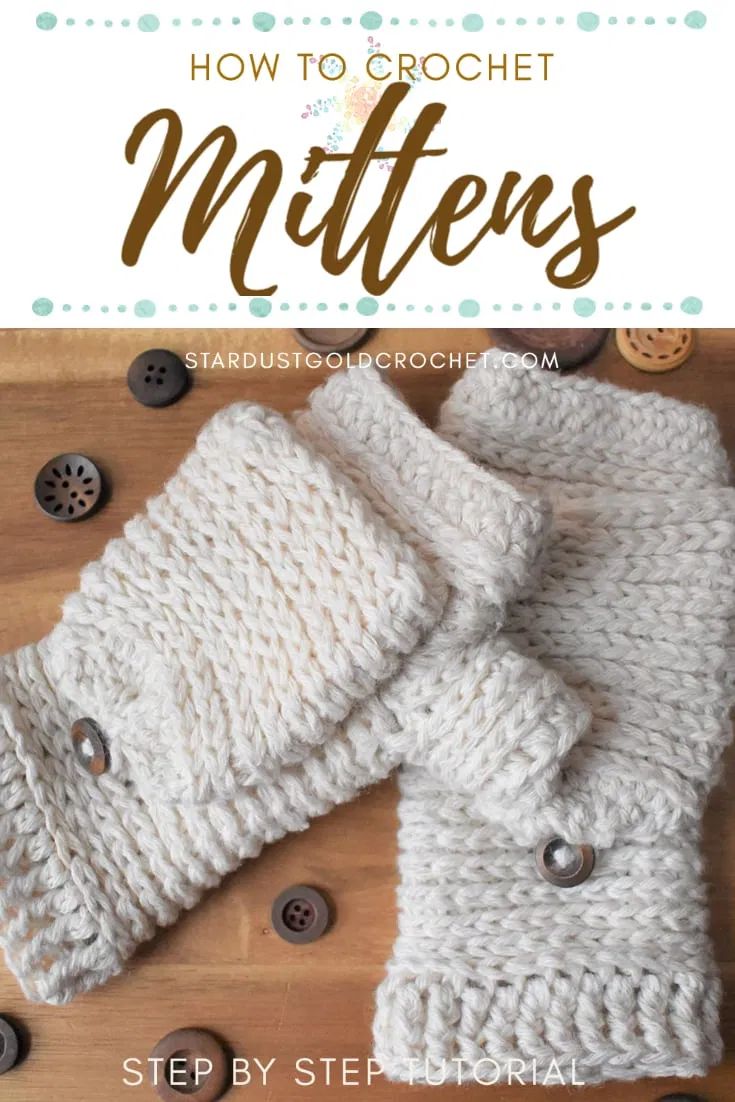 two white knitted mittens sitting on top of a wooden table next to buttons