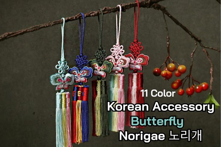 an assortment of korean accessories hanging from a tree branch with berries in the foreground