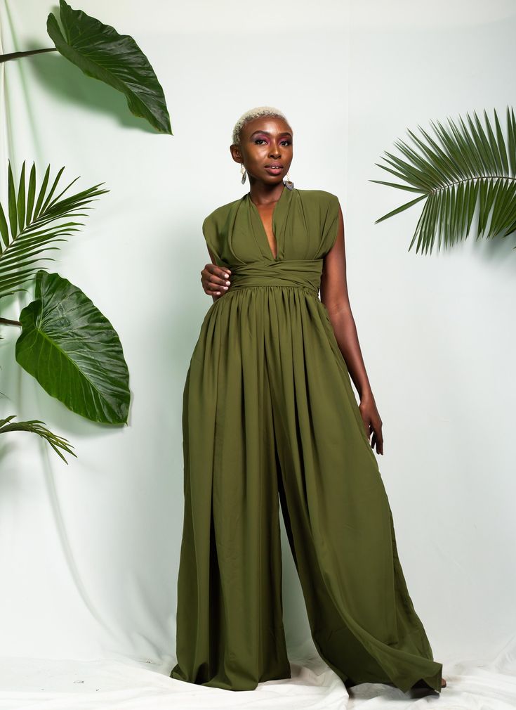 "The Abidjan Infinity Jumpsuit can be styled in multiple different ways. It is made out of polyester fabric. It is perfect for summer & spring. It has pockets on both sides. Length: 64\" (163 cm) The length can be adjusted on request. The model is wearing a UK 16. It has an elastic waistband. CARE INSTRUCTIONS It can be machine-washed. Colour: Moss Green SIZE GUIDE XXS/ UK 4 / US 0 = B -32 W -24 H -34 XS / UK 6 / US 2 = B -34 W -26 H - 36 S / UK 8 / US 4 = B - 35 W - 28 H -38 M / UK 10 / US Us Size 10 Women Outfits, Infinity Jumpsuit, Green Jumpsuit Outfit Wedding, Flowy Jumpsuit Outfit, Wedding Guest Jumpsuit Summer, Green Jumpsuit Outfit Classy, Summer Jumpsuits, Non Binary Wedding Guest Outfit, Jump Suits