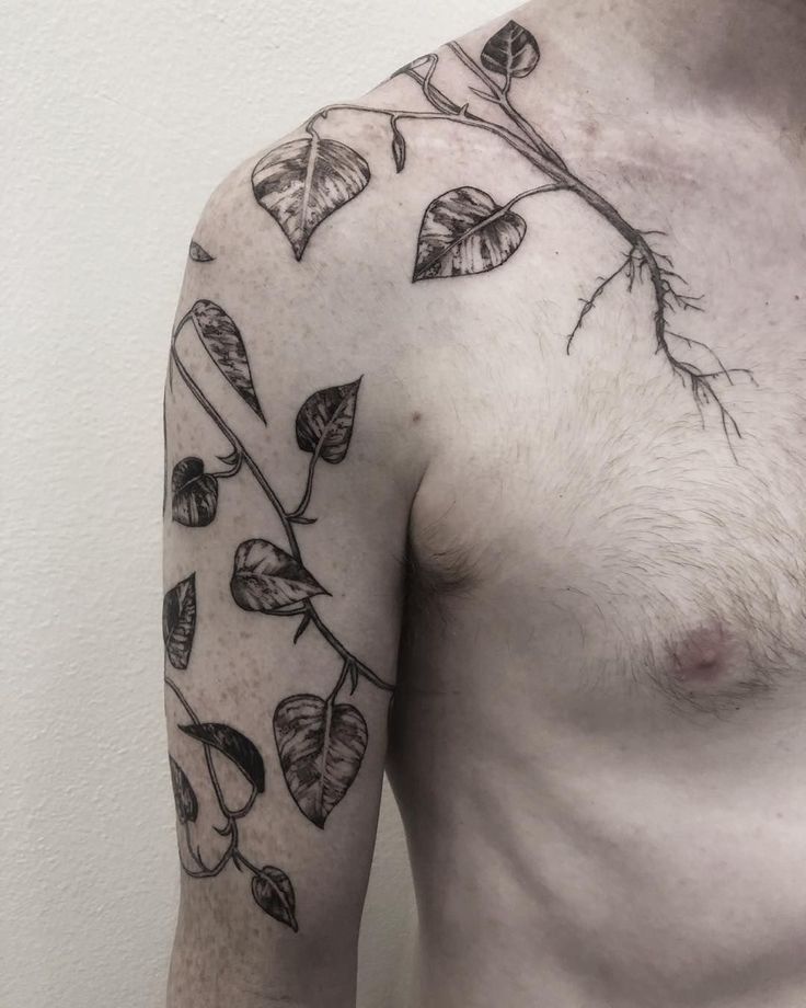 a man's chest with leaves and branches on his left arm, which are drawn in black ink