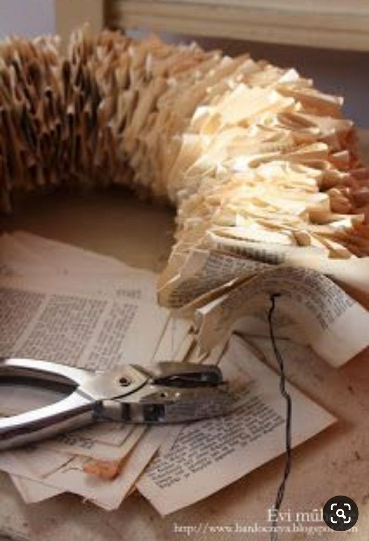 a pair of scissors sitting on top of some old books next to an open book