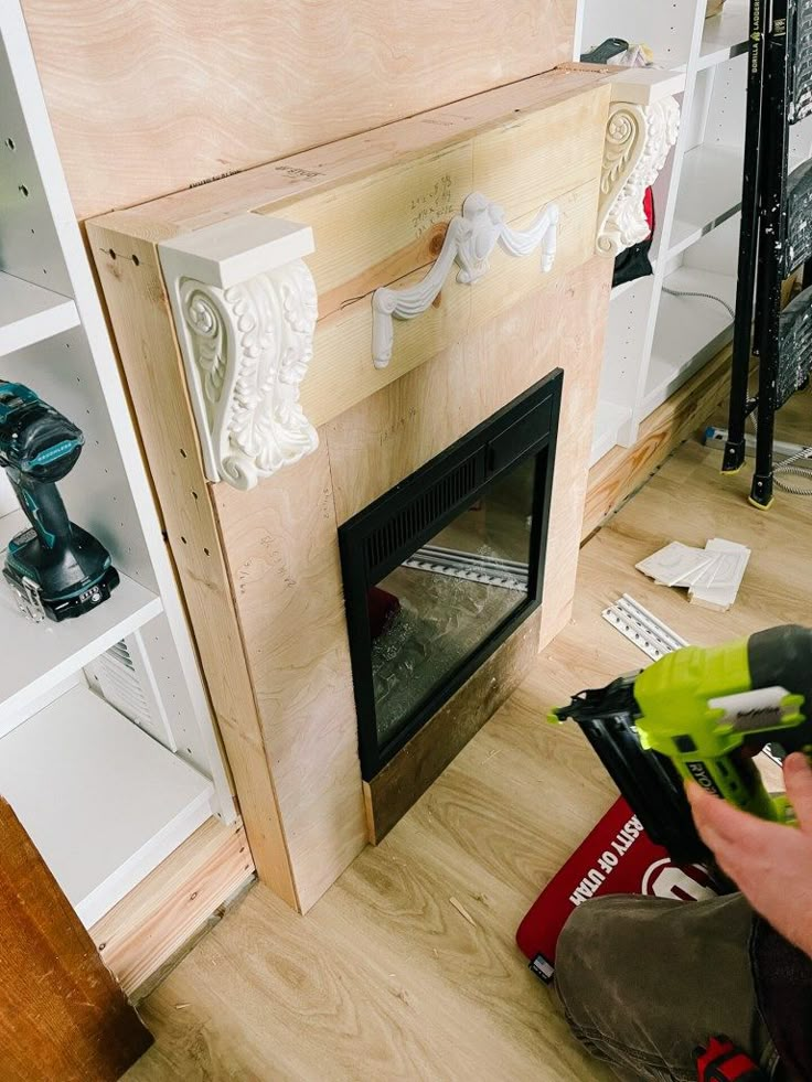 a man is working on a fireplace in the living room