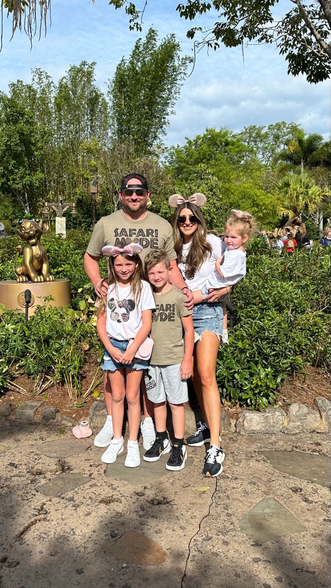 the family is posing for a photo in front of some trees and bushes at disney's animal kingdom